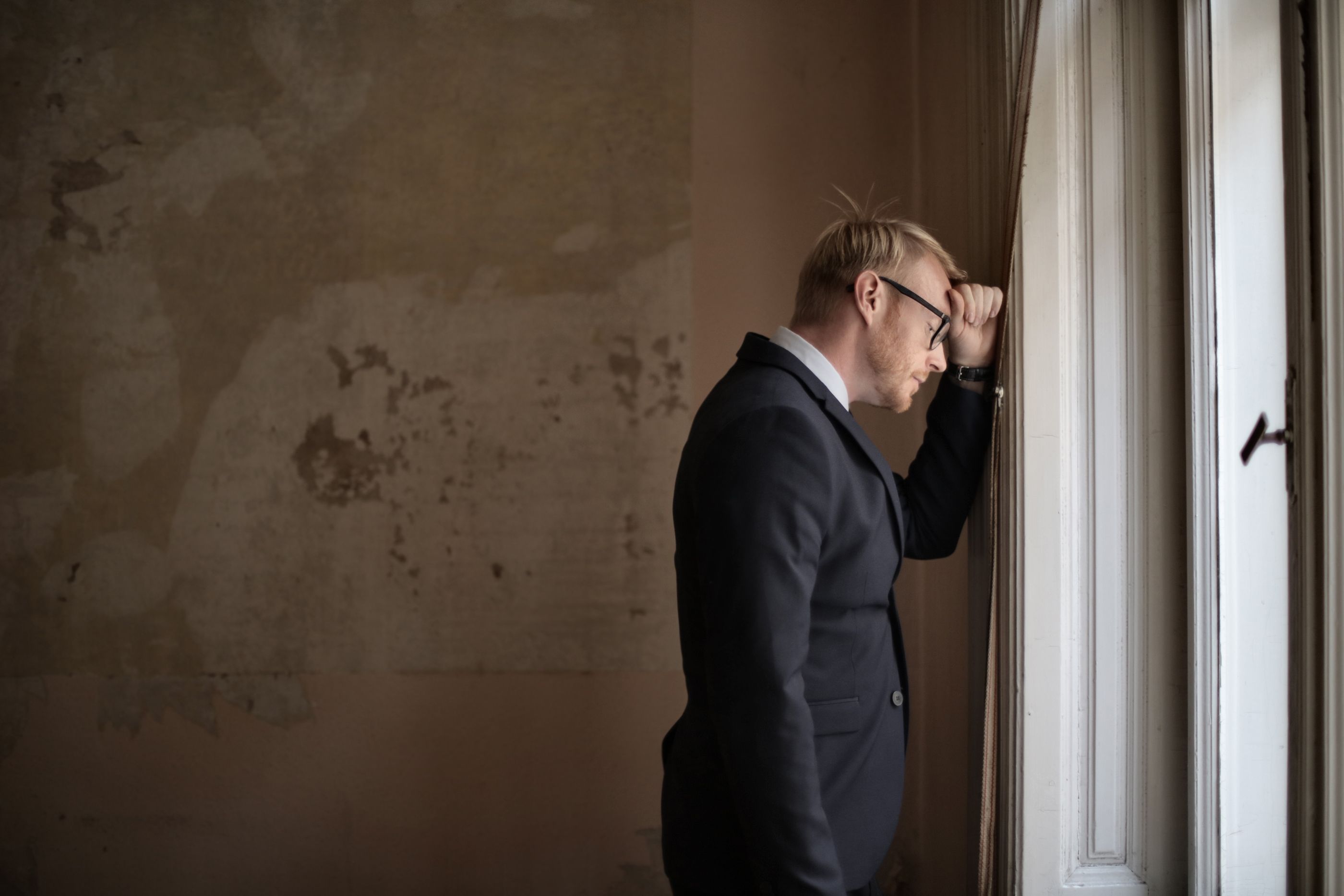 desperate-evicted-male-entrepreneur-standing-near-window-3771129